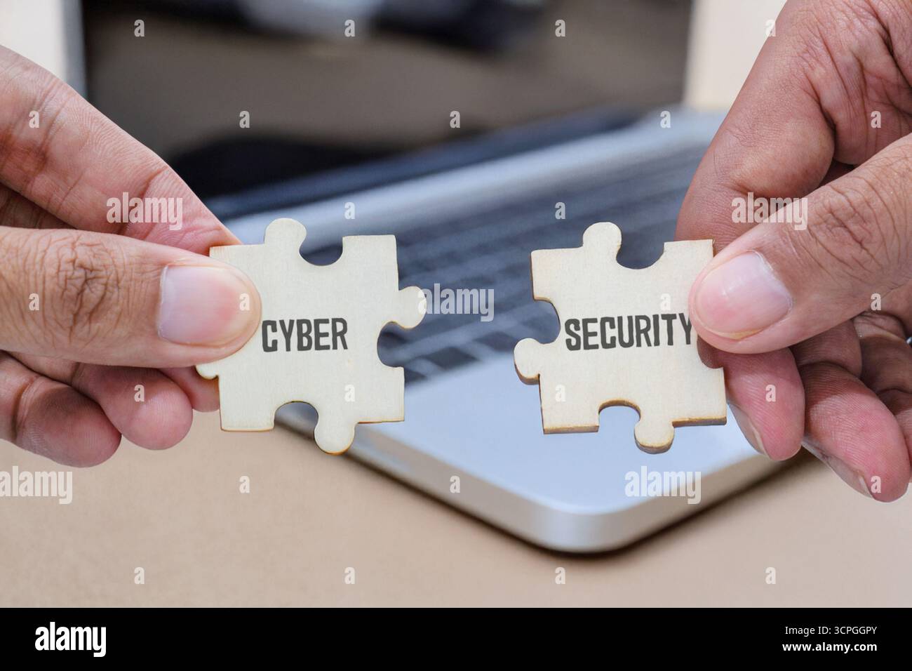 Hands holding two wooden jigsaw puzzle pieces labeled CYBER SECURITY. Digital security or cybersecurity concepts. Stock Photo