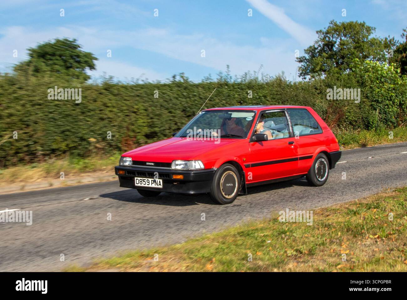 1987 80s eighties Red Toyota Corolla E90 series, Gl Auto hatchback Car Petrol 1295 cc;  travelling at speed to the Cheshire Classic car show, UK Stock Photo