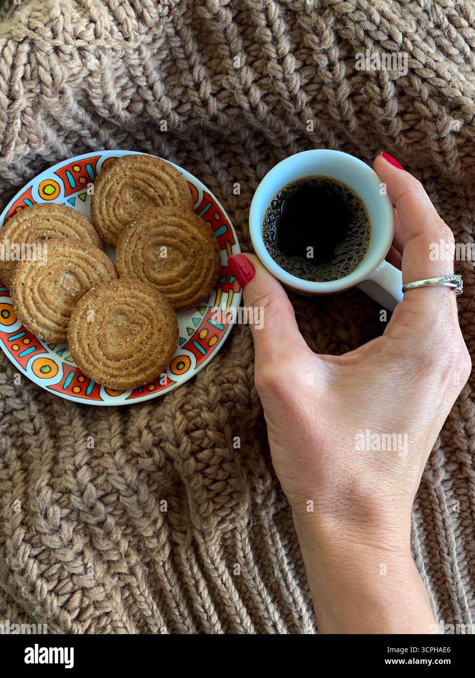Female hand holding cup of coffee on autumn background. Brown sweater, coffee and biscuits. Autumn mood flat lay. Concept cozy coffee cup. Top view. - Smartphone Captured Stock Image