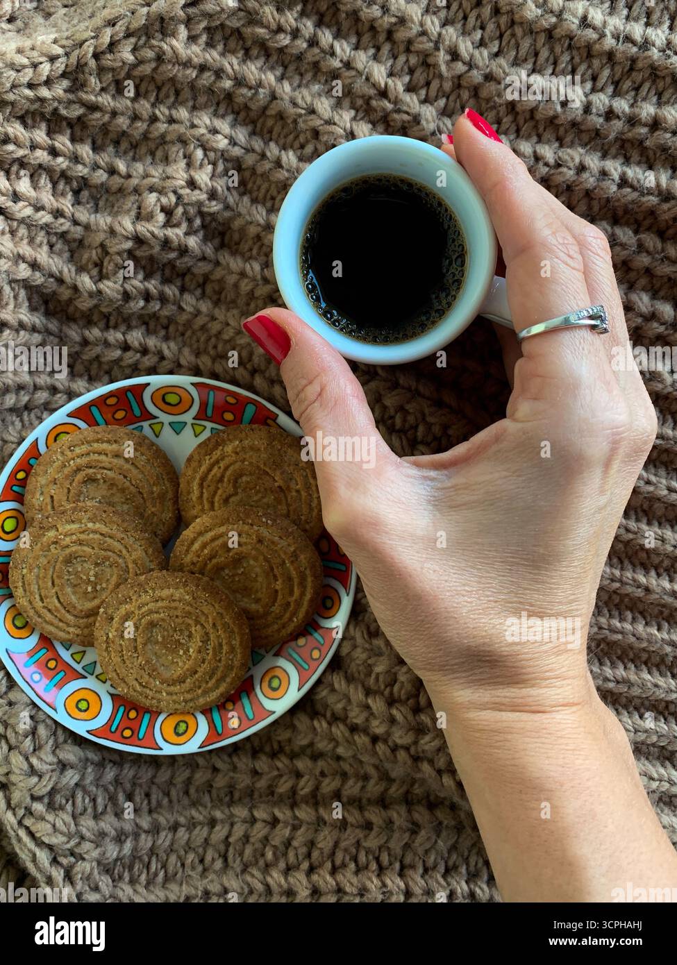 Female hand holding cup of coffee on autumn background. Brown sweater, coffee and biscuits. Autumn mood flat lay. Concept cozy coffee cup. Top view. - Smartphone Captured Stock Image