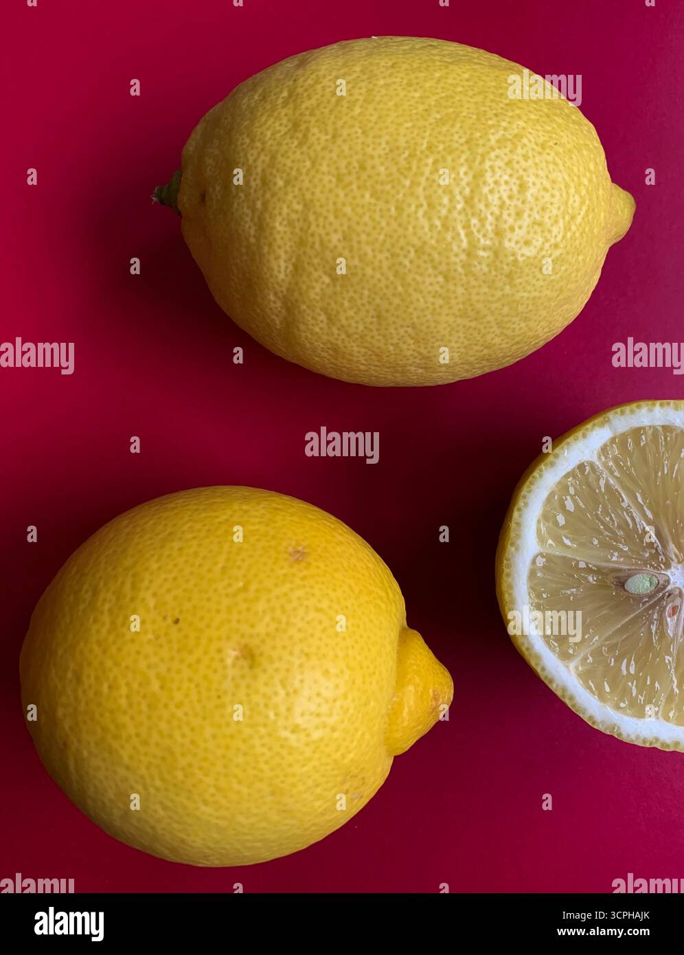 Fresh lemon pattern on a vivid pink background. Flat lay. Lemons. Vitamin C. Creative minimal art. Minimal summer concept. Whole and halved lemon. - Smartphone Captured Stock Image