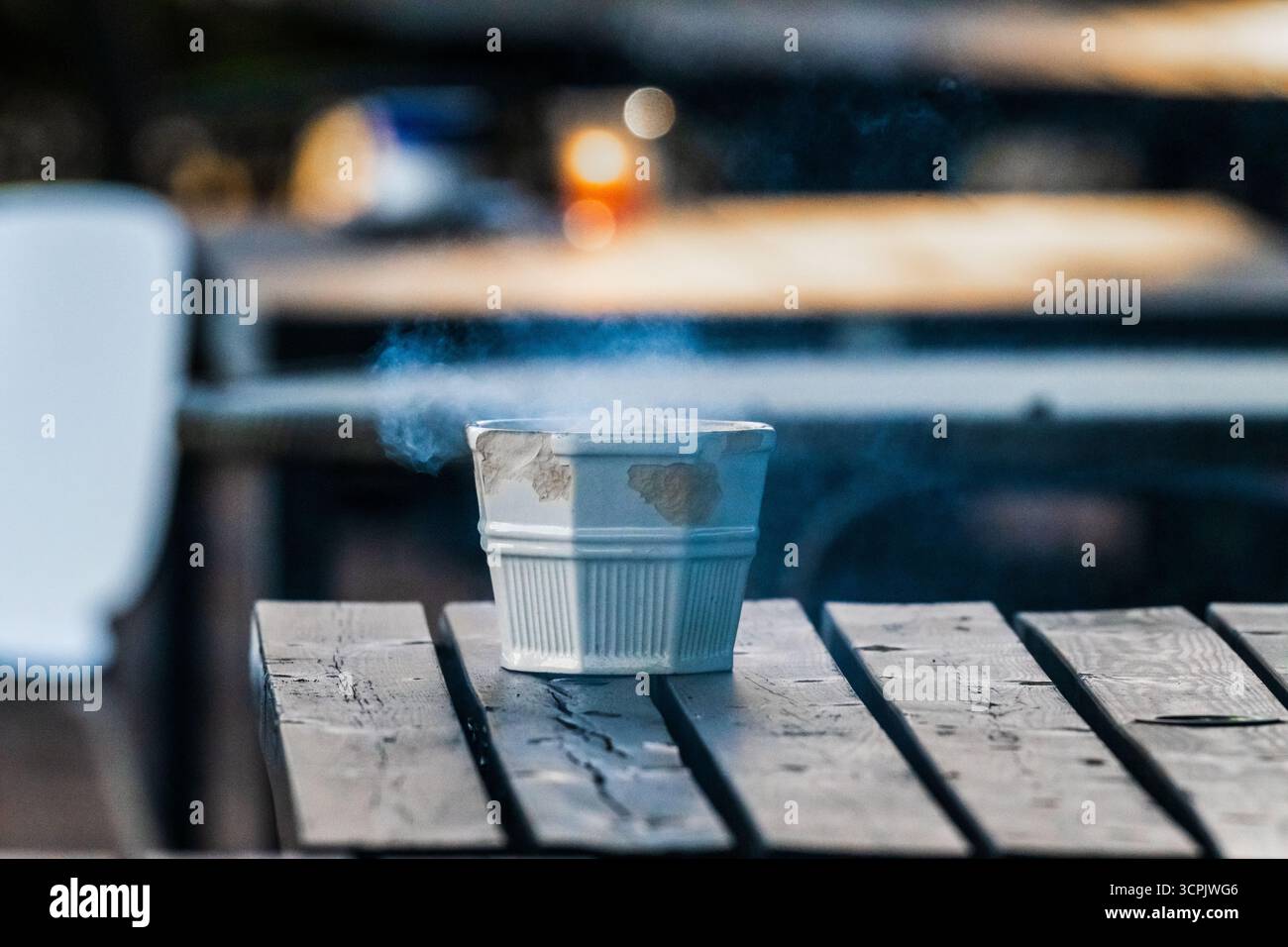 Smoke rising from an ashtray on a table Stock Photo