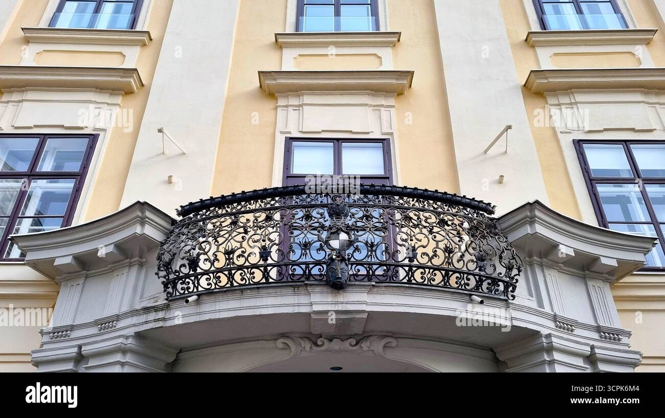 Balcony with wrought iron baroque grille on the facade of a cream-colored building in historical part of Vienna, Austria Stock Photo