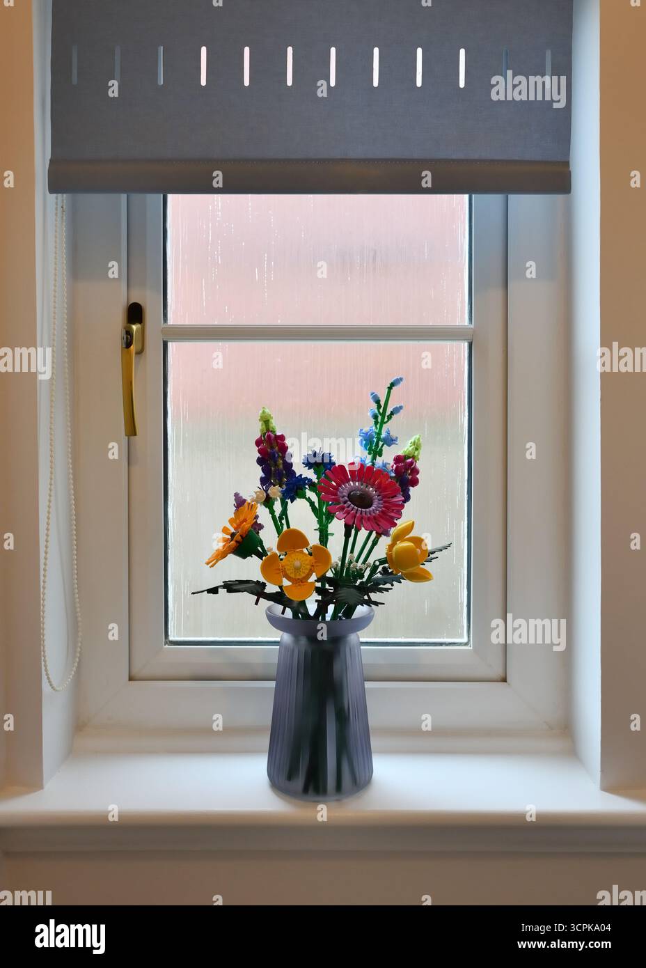 Colourful Lego flowers adorn a window sill. Stock Photo