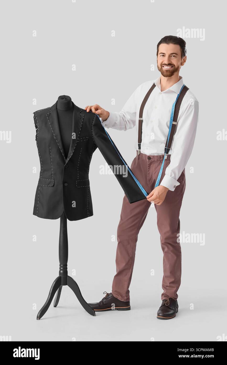 Male tailor measuring jacket on white background Stock Photo