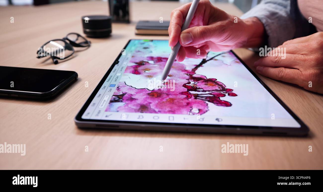 Creative Designer Editing Digital Artwork On Tablet At Desk Stock Photo