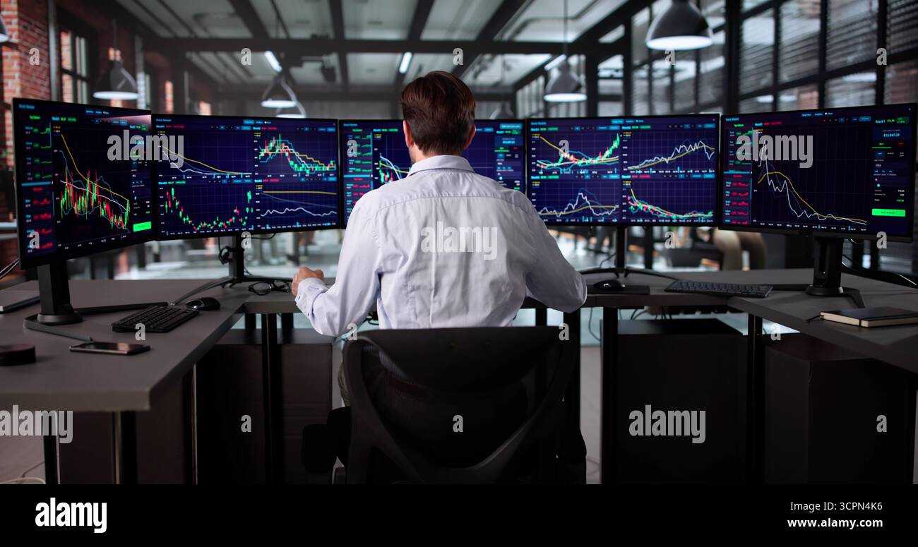 Senior Broker Analyzing Stock Market Data On Multiple Computer Screens. Stock Photo