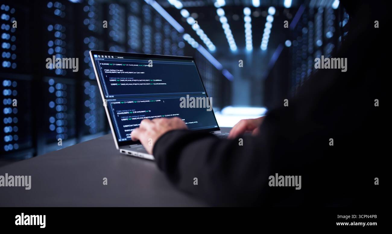 Man In Mask Hacking Server For Identity Theft And Scam. Stock Photo