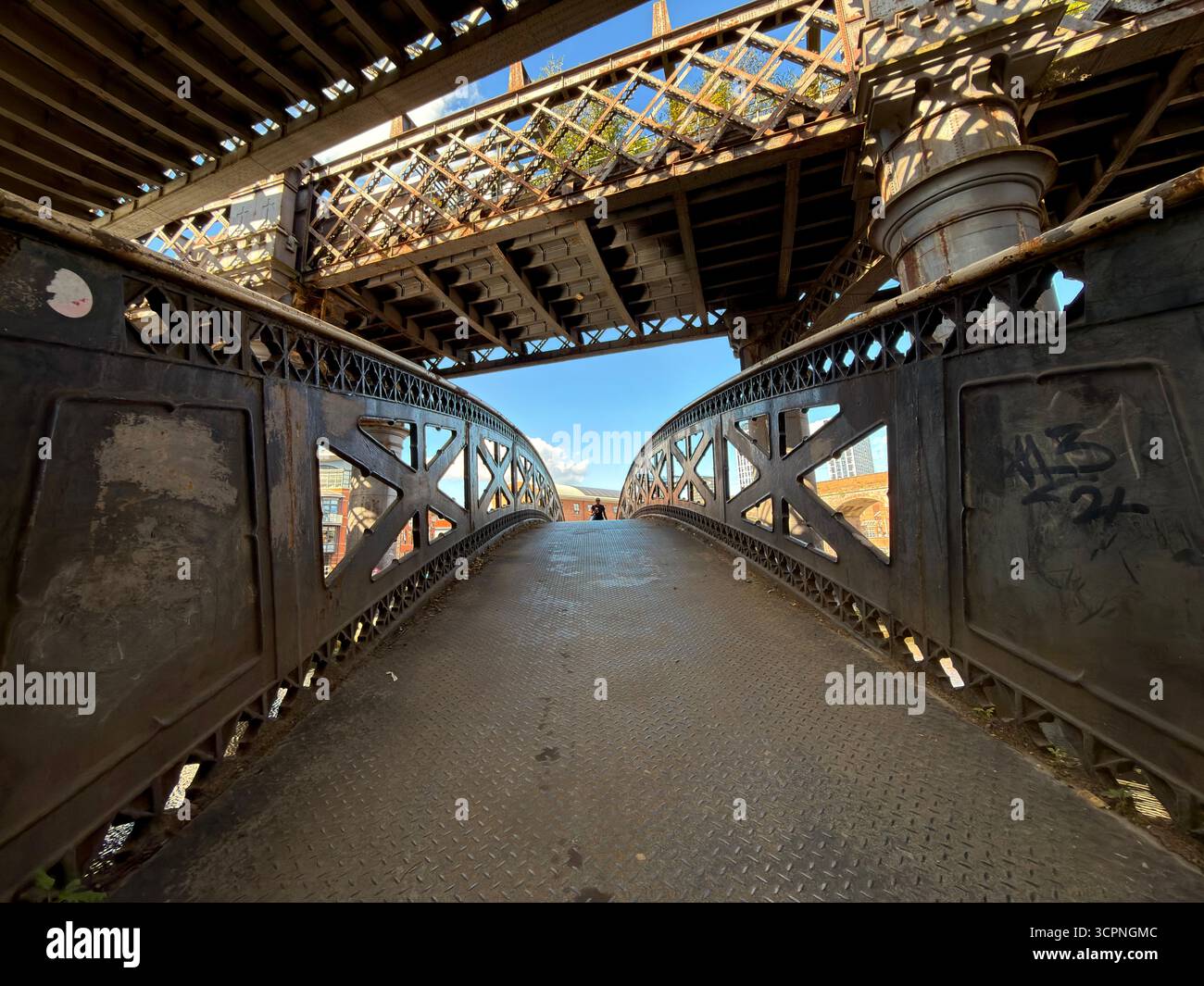 Castlefield basin in Manchester City centre. Iron footbridge and railway bridge either figure in distance - Smartphone Captured Stock Image