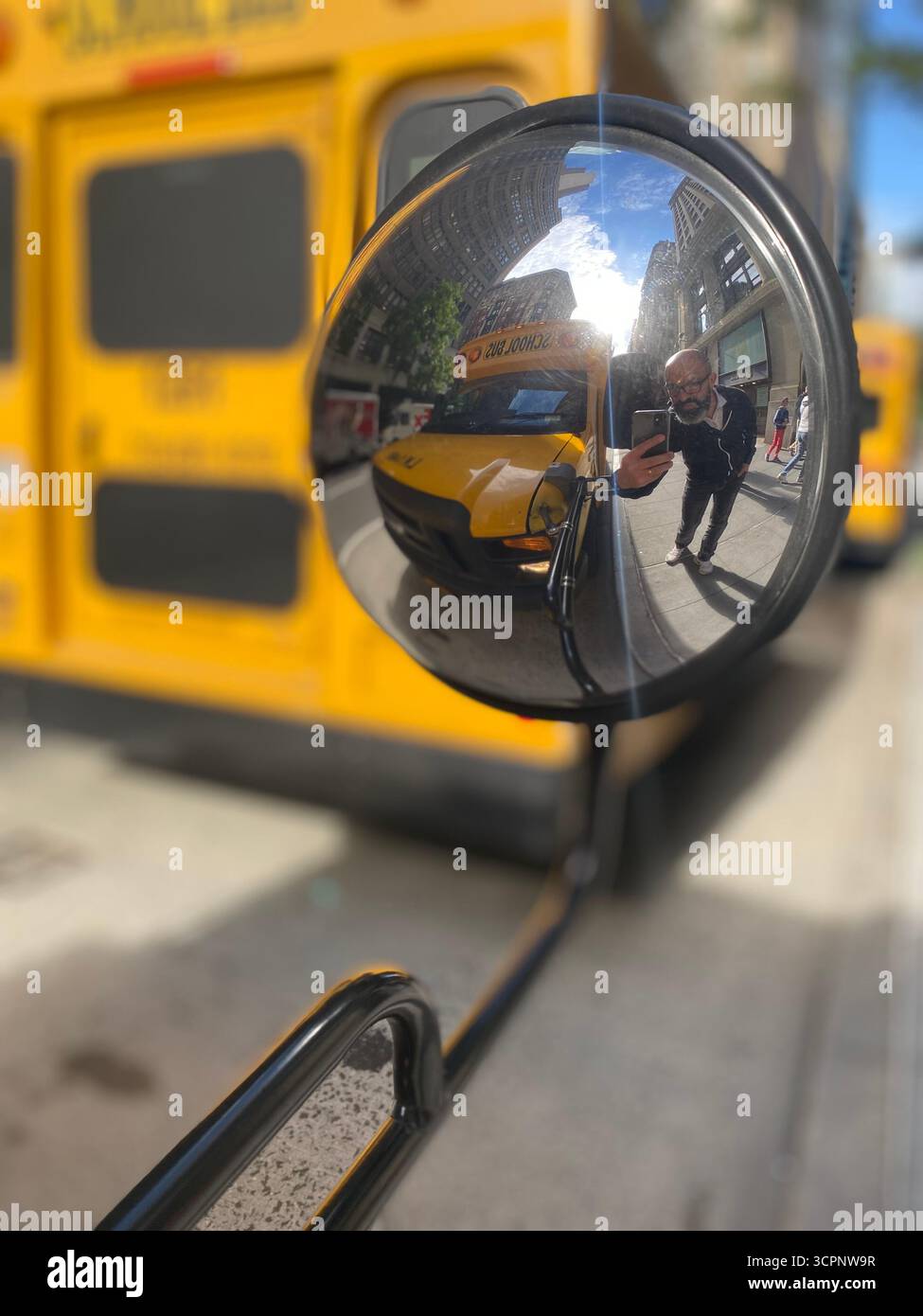 Reflections of City Life: School Bus Mirror Scene - Smartphone Captured Stock Image