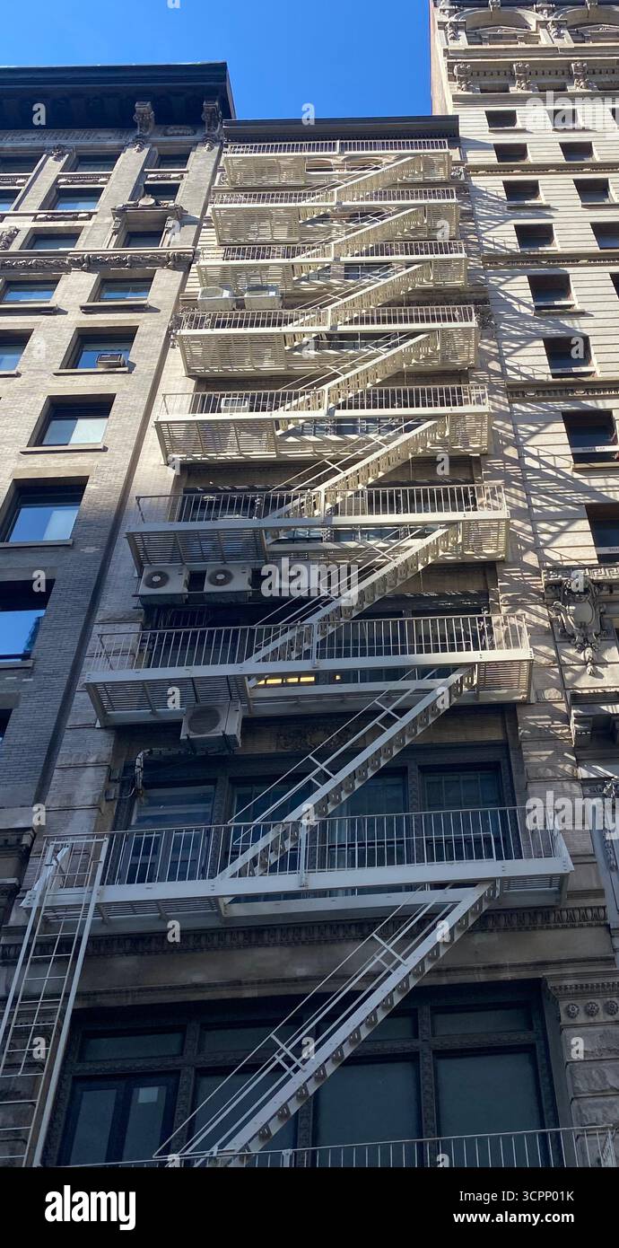 Urban Brick Building with Metal Fire Escape and Air Conditioners in New York City - Smartphone Captured Stock Image