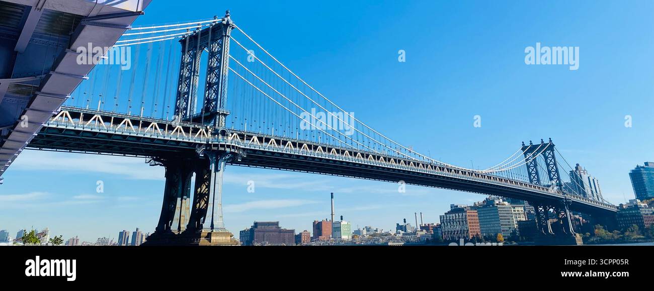 Manhattan Bridge Spanning East River with Urban Skyline and Industrial Buildings in New York City - Smartphone Captured Stock Image