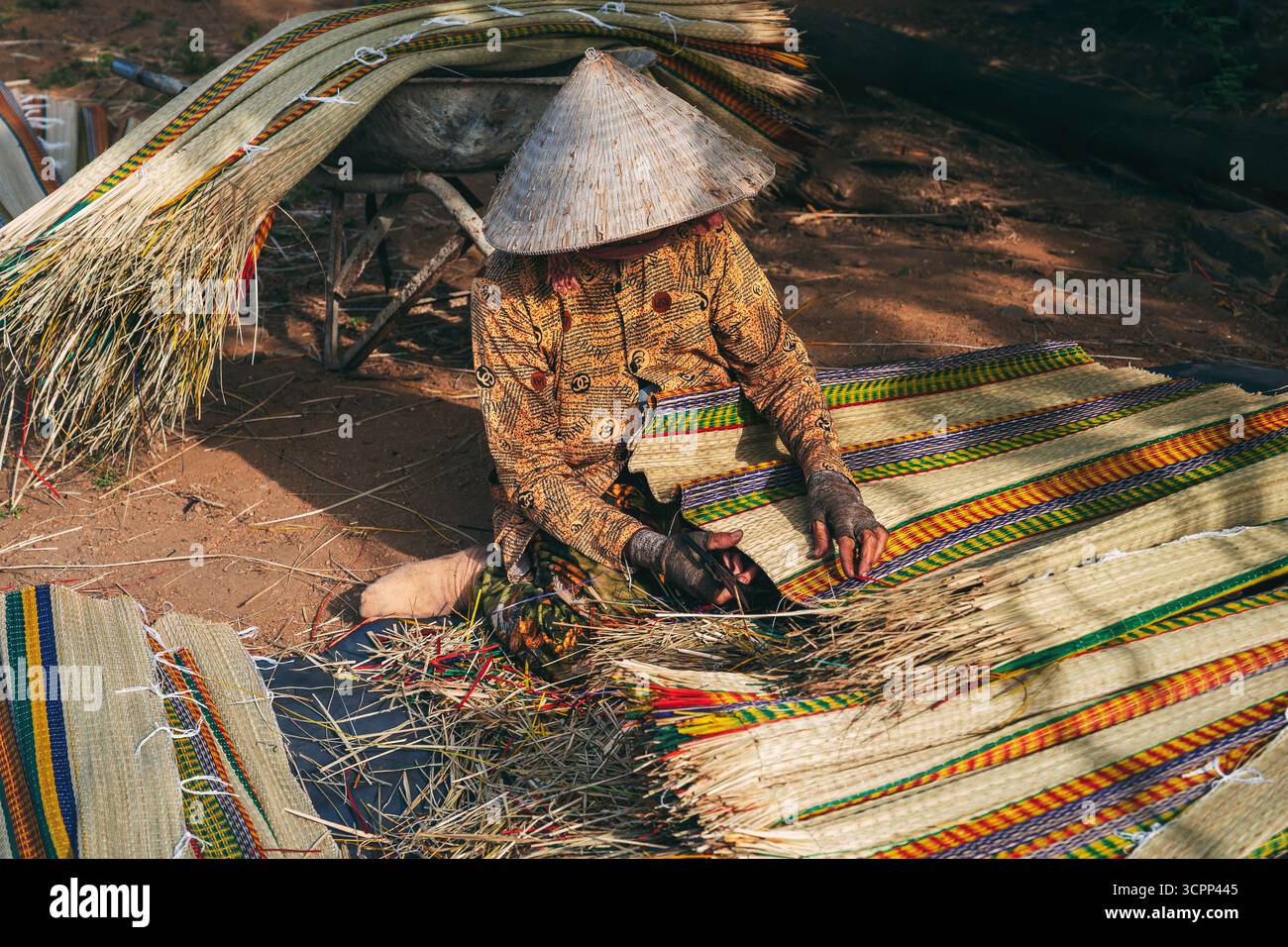Vietnamese woman in traditional straw hat works at reed mat factory in ...
