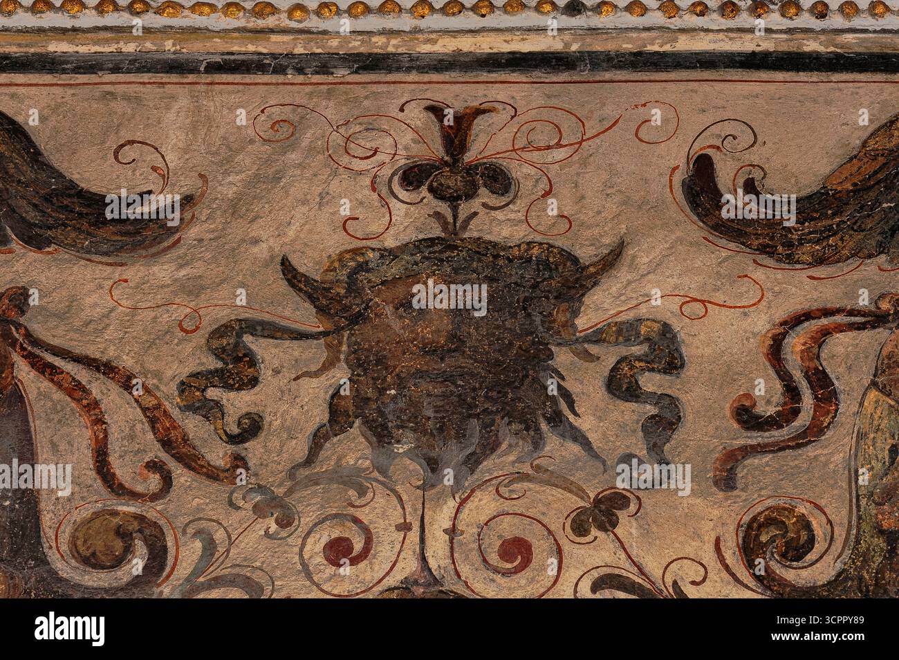 Gilded ram horns and long pointed ears: face of faun with staring eyes ...