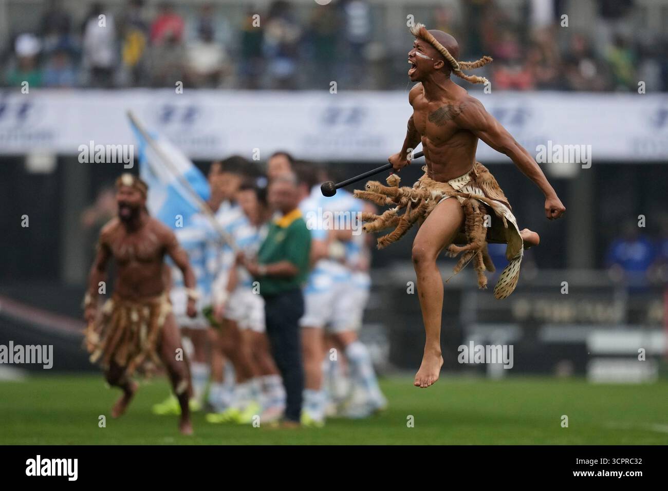A traditional dancer jumps as Argentina's players line up for a rugby ...