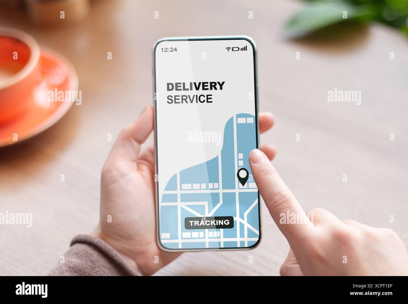 Woman using smartphone with opened delivery service tracking app, checking order status Stock Photo