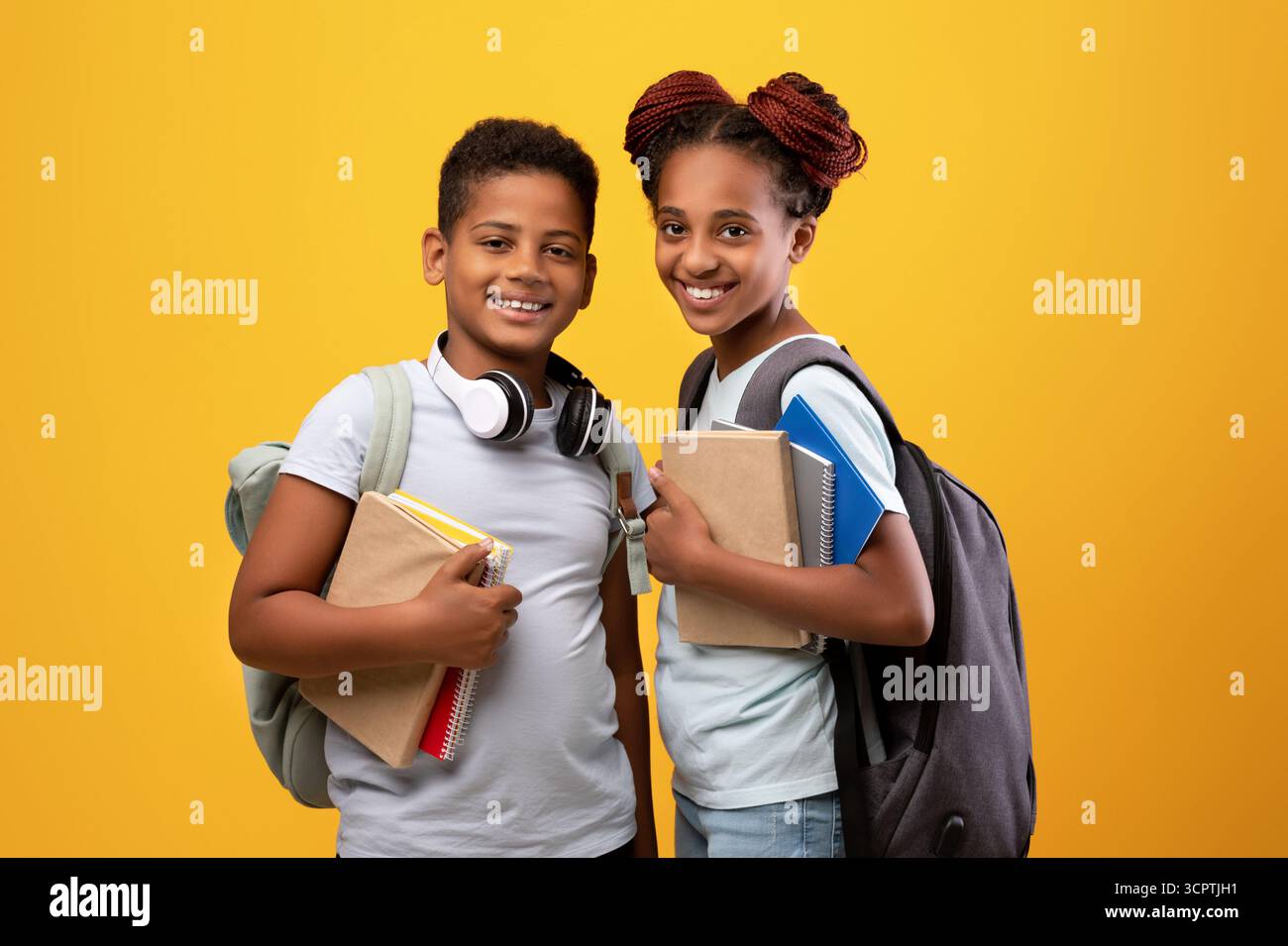 Positive black boy and girl schoolers holding books Stock Photo - Alamy