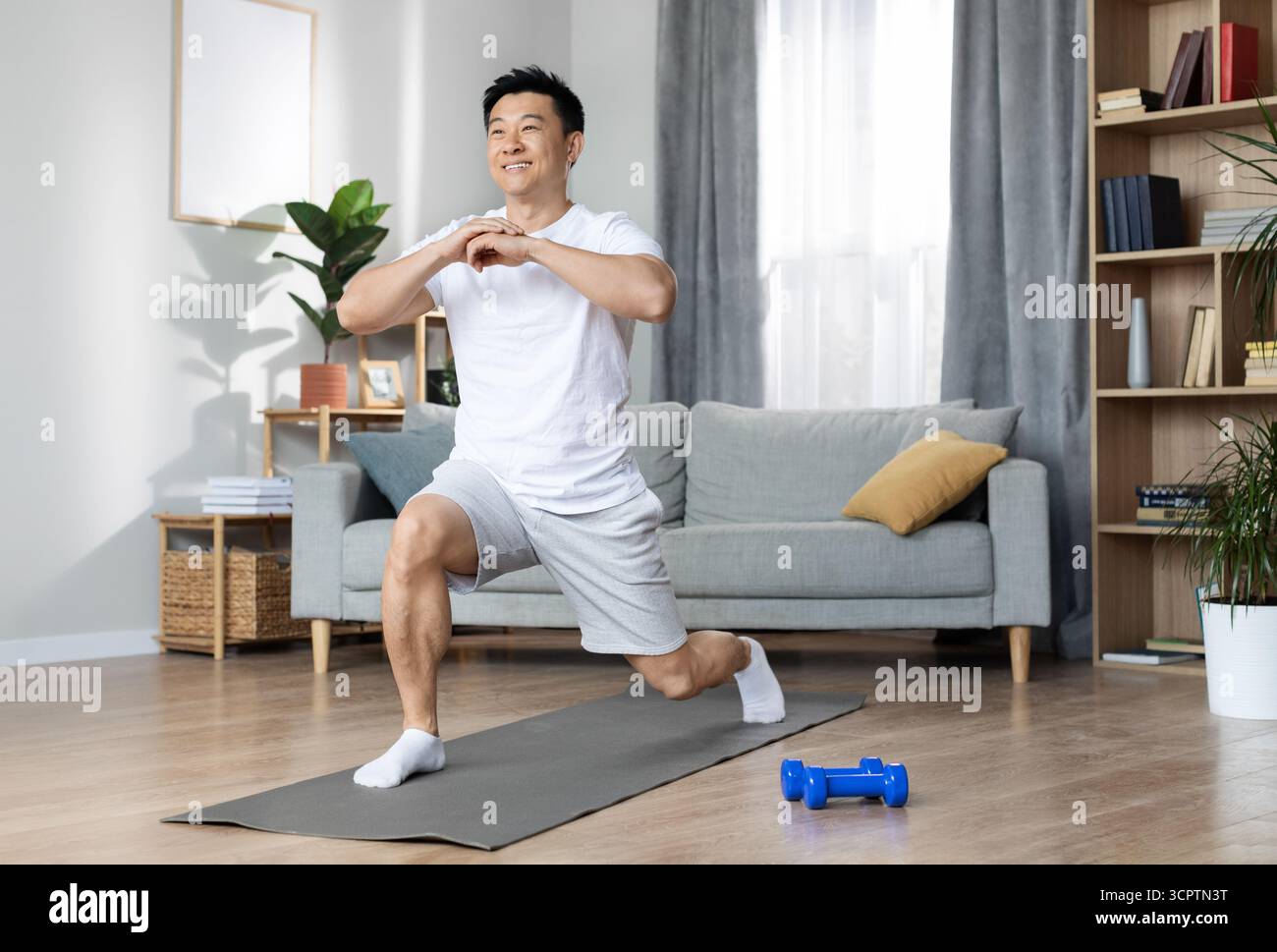 Athletic asian man training alone at home Stock Photo