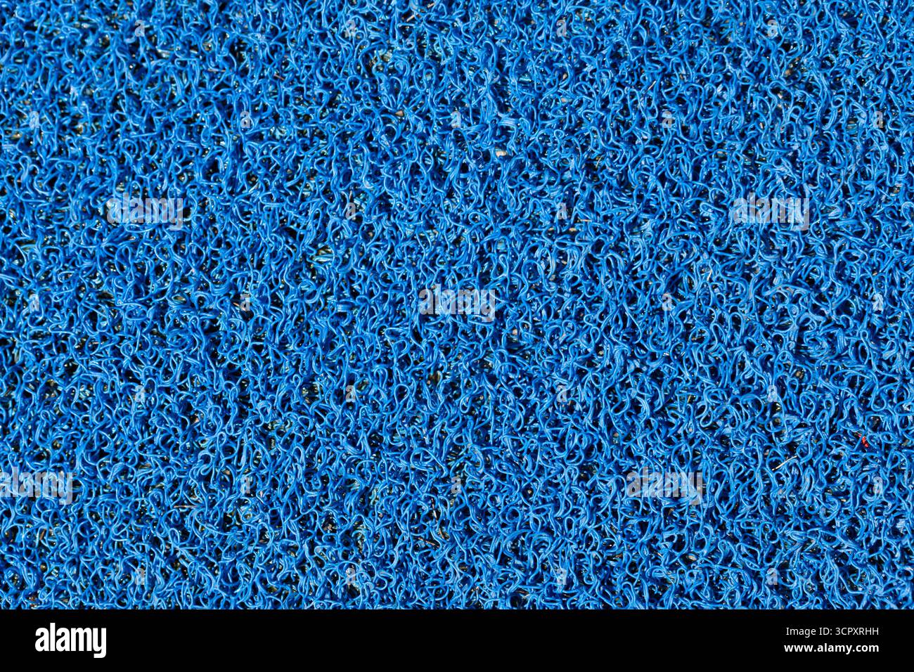 Close-up of a blue, densely packed, looped-pile mat. The texture fills the entire frame. Stock Photo