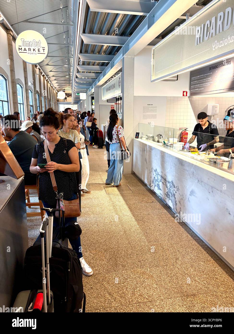 Time Out market Porto, customers sitting inside enjoying lunch and drinks, socialising with friends, Portugal,Europe - Smartphone Captured Stock Image