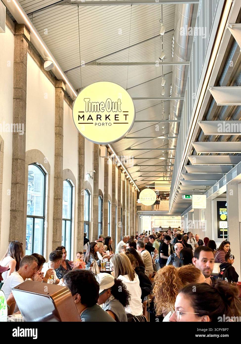Time Out market Porto, customers sitting inside enjoying lunch and drinks, socialising with friends, Portugal,Europe - Smartphone Captured Stock Image