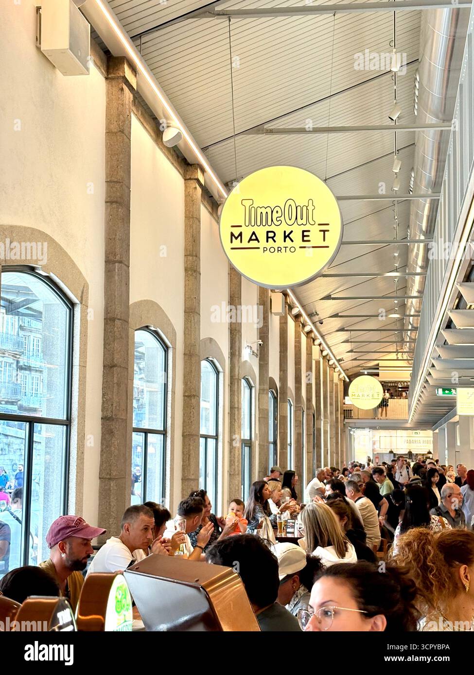 Time Out market Porto, customers sitting inside enjoying lunch and drinks, socialising with friends, Portugal,Europe - Smartphone Captured Stock Image