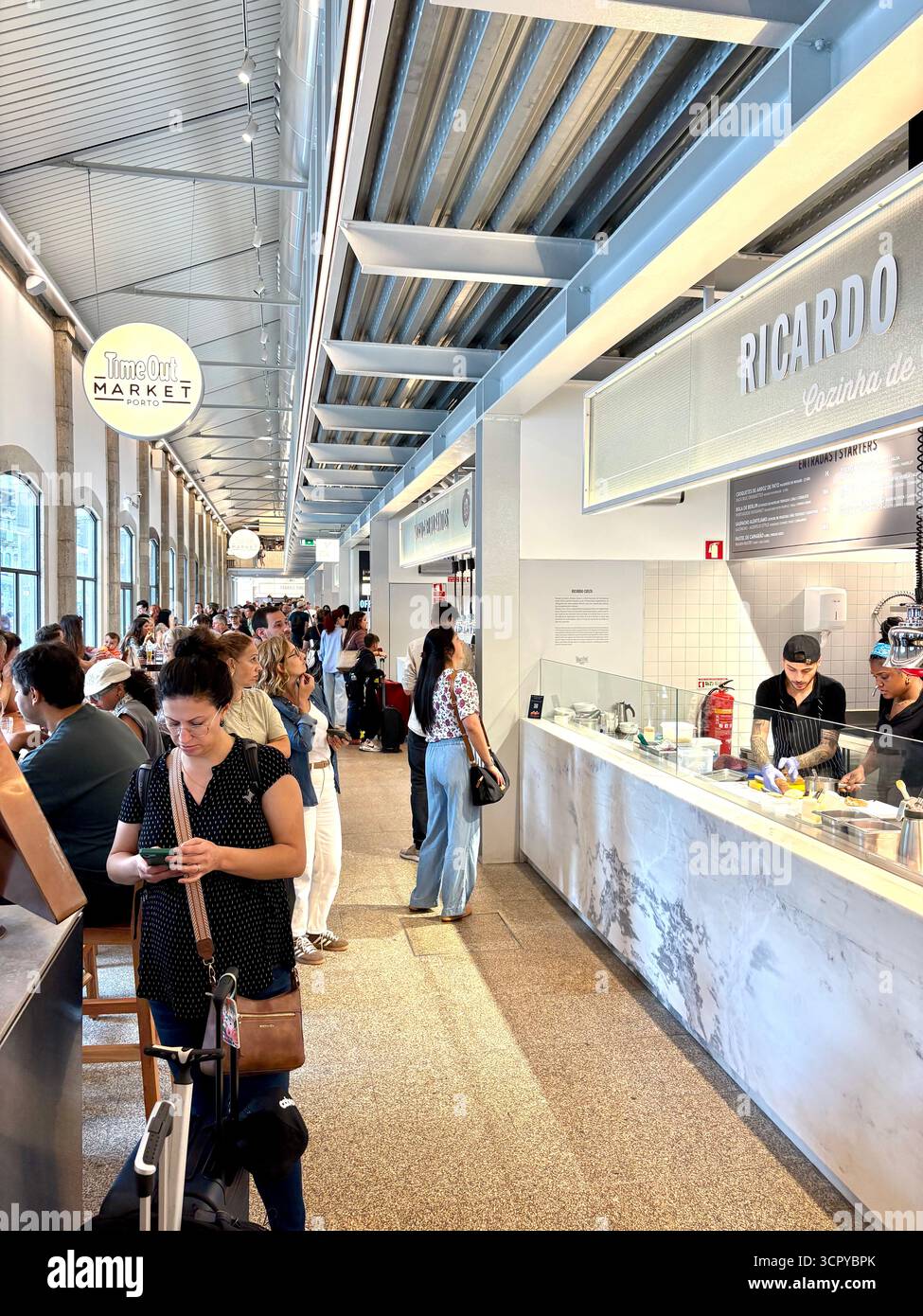Time Out market Porto, customers sitting inside enjoying lunch and drinks, socialising with friends, Portugal,Europe - Smartphone Captured Stock Image