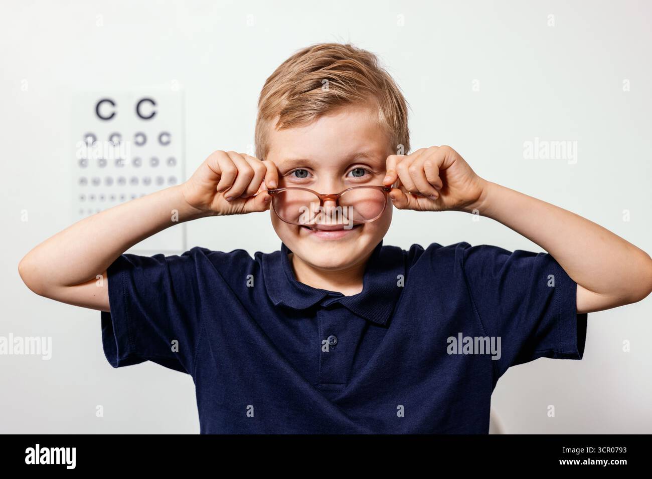 smiling child with optical eyeglasses during eye examination Stock Photo