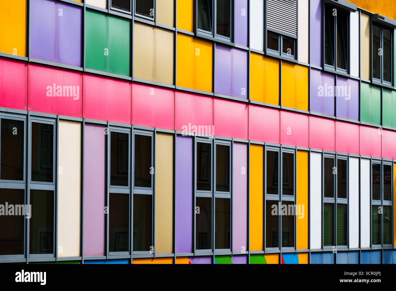 Colorful modern facade with geometric panels and rhythmic window ...