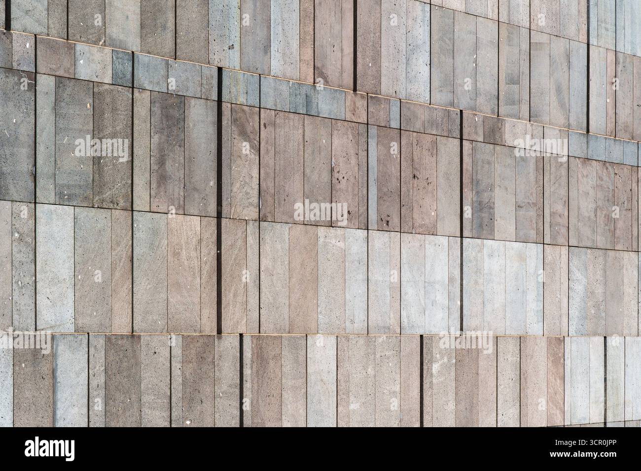 Minimalist stone wall with rectangular tiles in natural tones and subtle geometric texture pattern Stock Photo