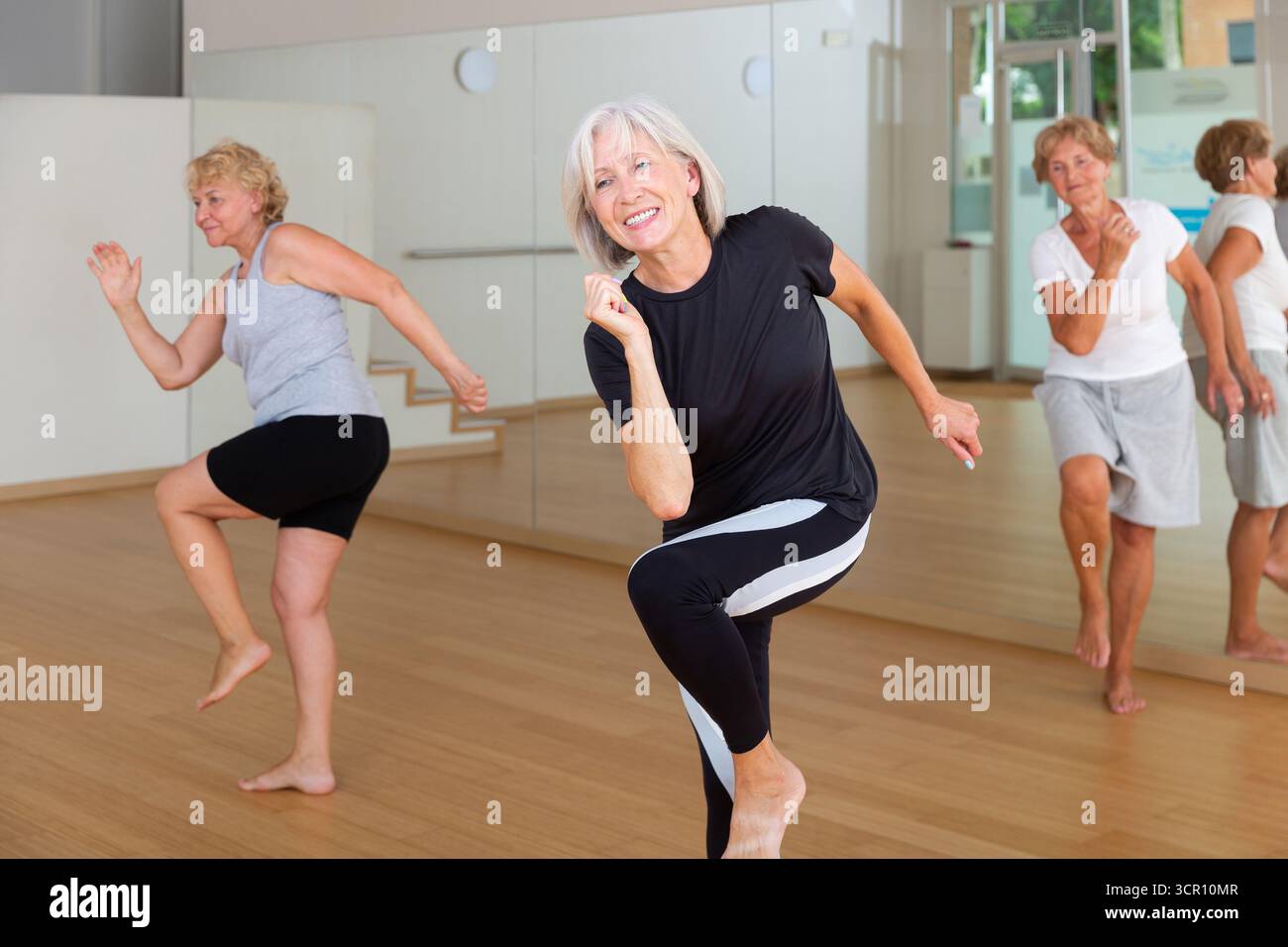 Active mature woman learning dynamic dances in choreography class Stock Photo