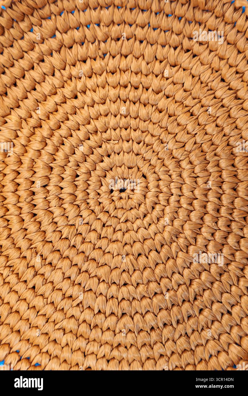 Circular weaving from natural raffia, close up. Stock Photo
