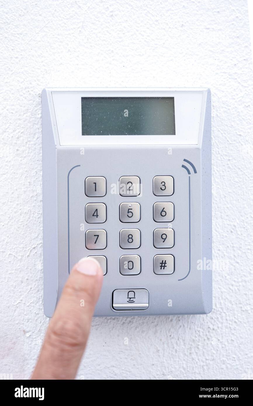 out of focus finguer pressing a button on a numeric keypad for a ...