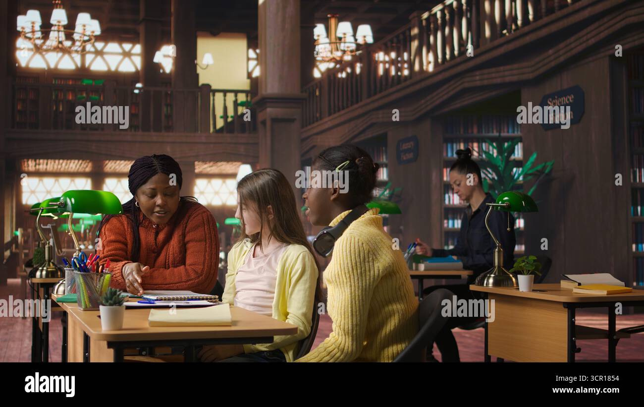Satisfied teenagers students doing high five next to tutor in the library, feeling happy with their progress on school subjects. Professor being proud of her scholars at private lessons. Camera A. Stock Photo