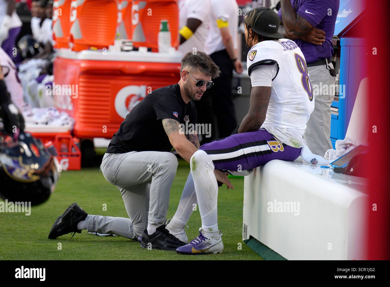 Baltimore Ravens quarterback Lamar Jackson sits on the bench as his leg ...