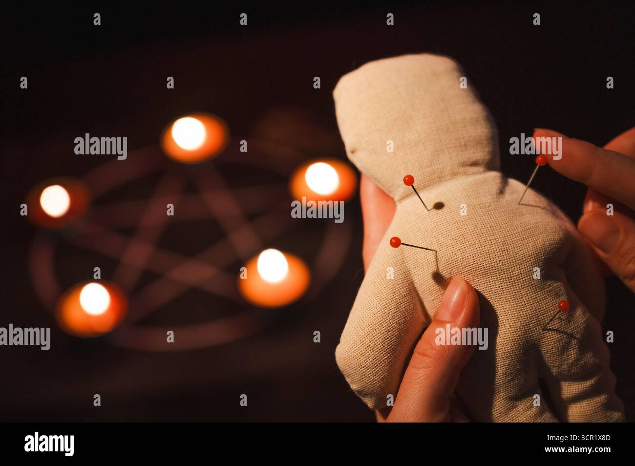 Woman sticking pins into voodoo doll Stock Photo - Alamy