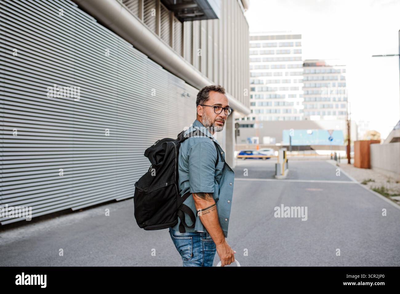 Handsome man with tattoos walking down the street. Stock Photo