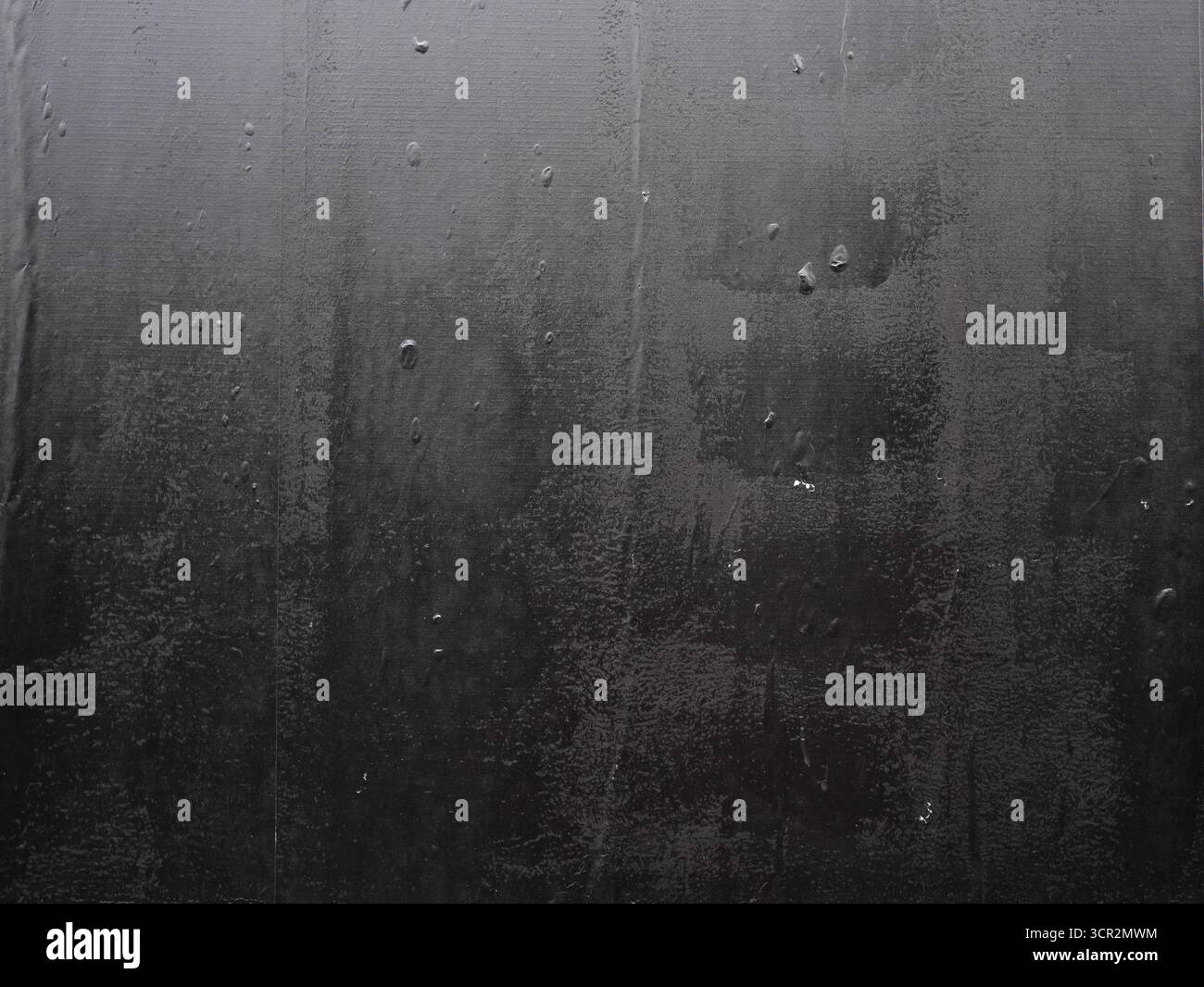 Imperfect black wheatpaste poster texture with air bubbles underneath Stock Photo