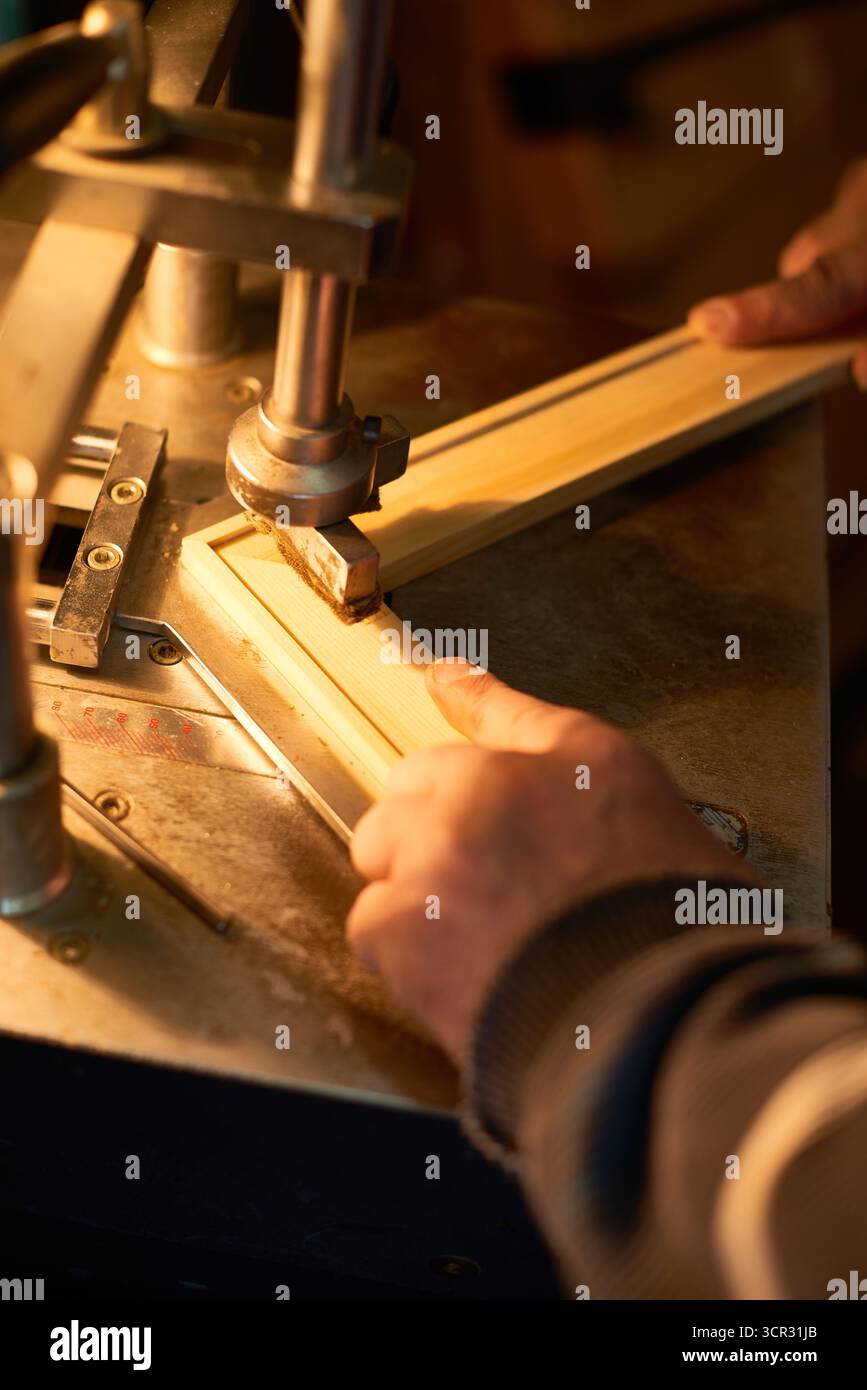 Man Assembling Wooden Frame Using Industrial Machine Stock Photo