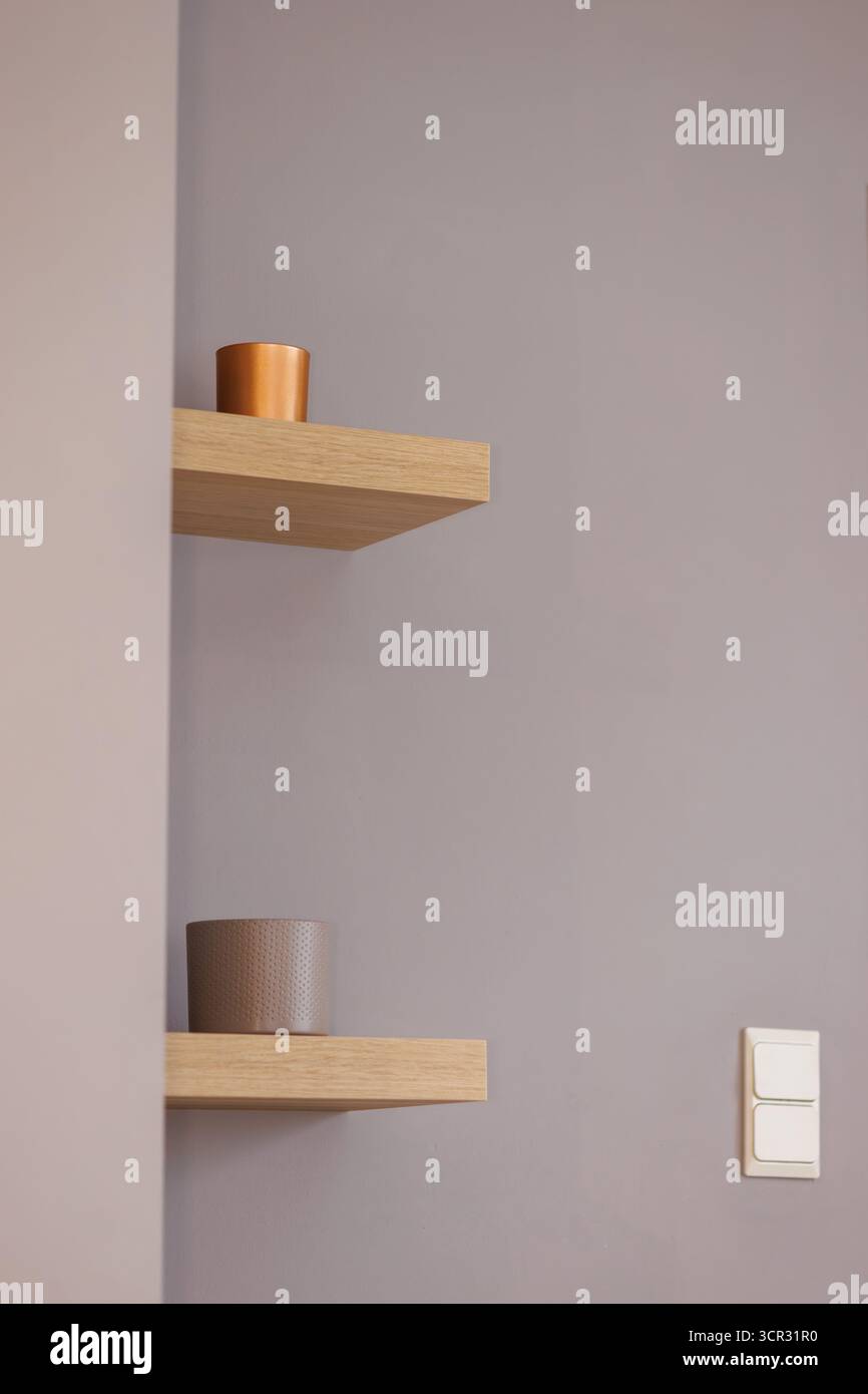 Minimalist wooden shelves on grey wall Stock Photo