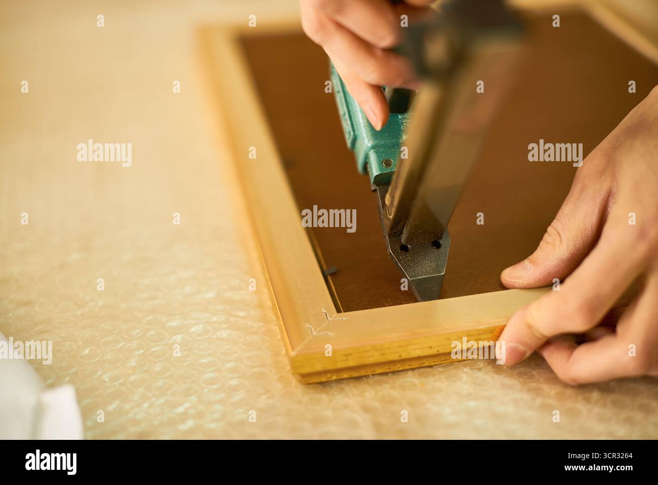 Man Assembling Wooden Frame Using Staple Gun Stock Photo