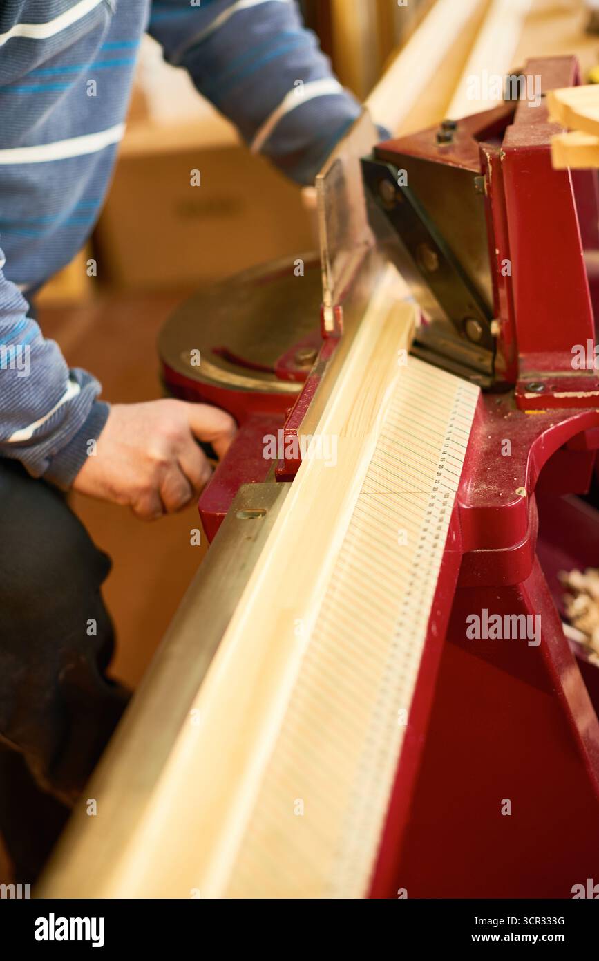 Man Operating Wood Cutting Machine in Workshop Stock Photo