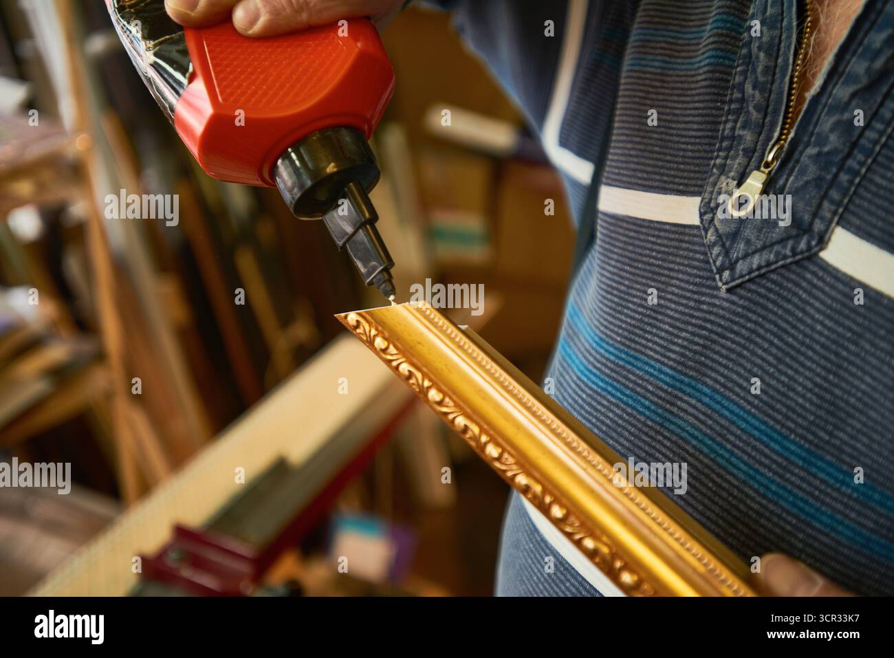 Man Assembling Ornate Frame Using Electric Screwdriver Stock Photo