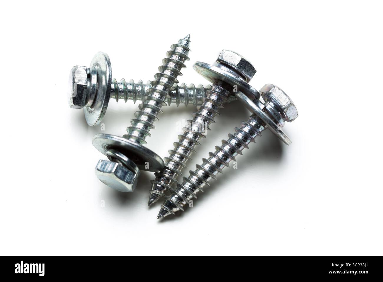 Metal screws stacked on a white background ready for construction projects Stock Photo