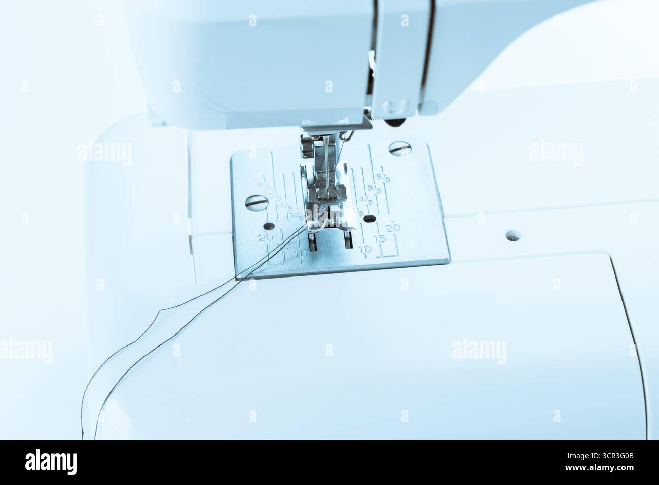 Sewing machine in use during daylight hours showcasing needle and thread activity Stock Photo