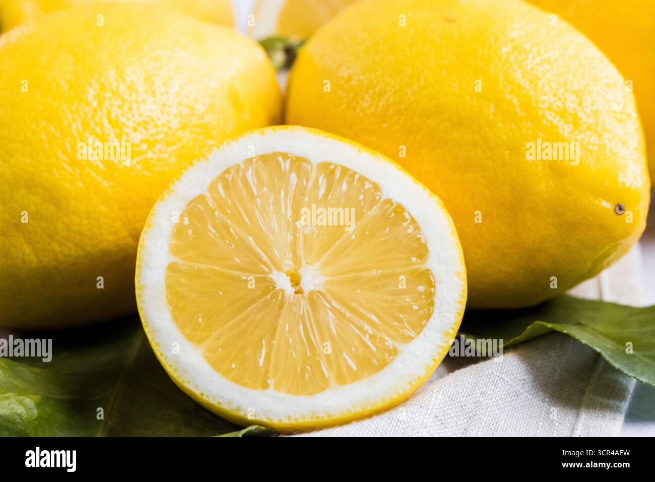 Fresh Lemons, Whole and Sliced on a Rustic Background Stock Photo