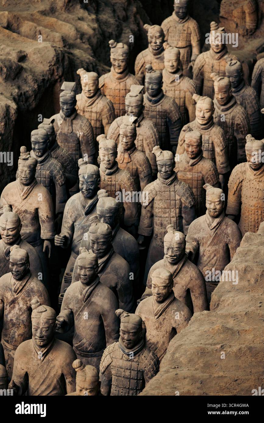Rows of ancient terracotta warriors in an excavation site, standing in ...