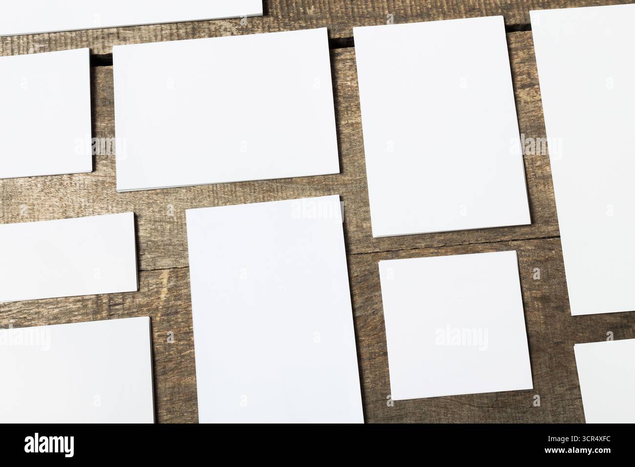 Blank rectangular cards arranged on a wooden surface with natural lighting Stock Photo