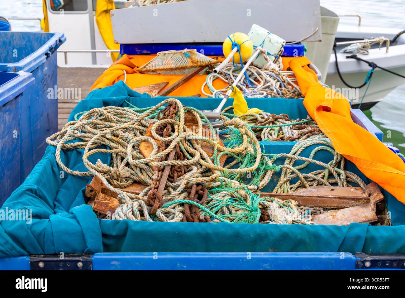 Fishing boat with tangled ropes and equipment in blue containers ...
