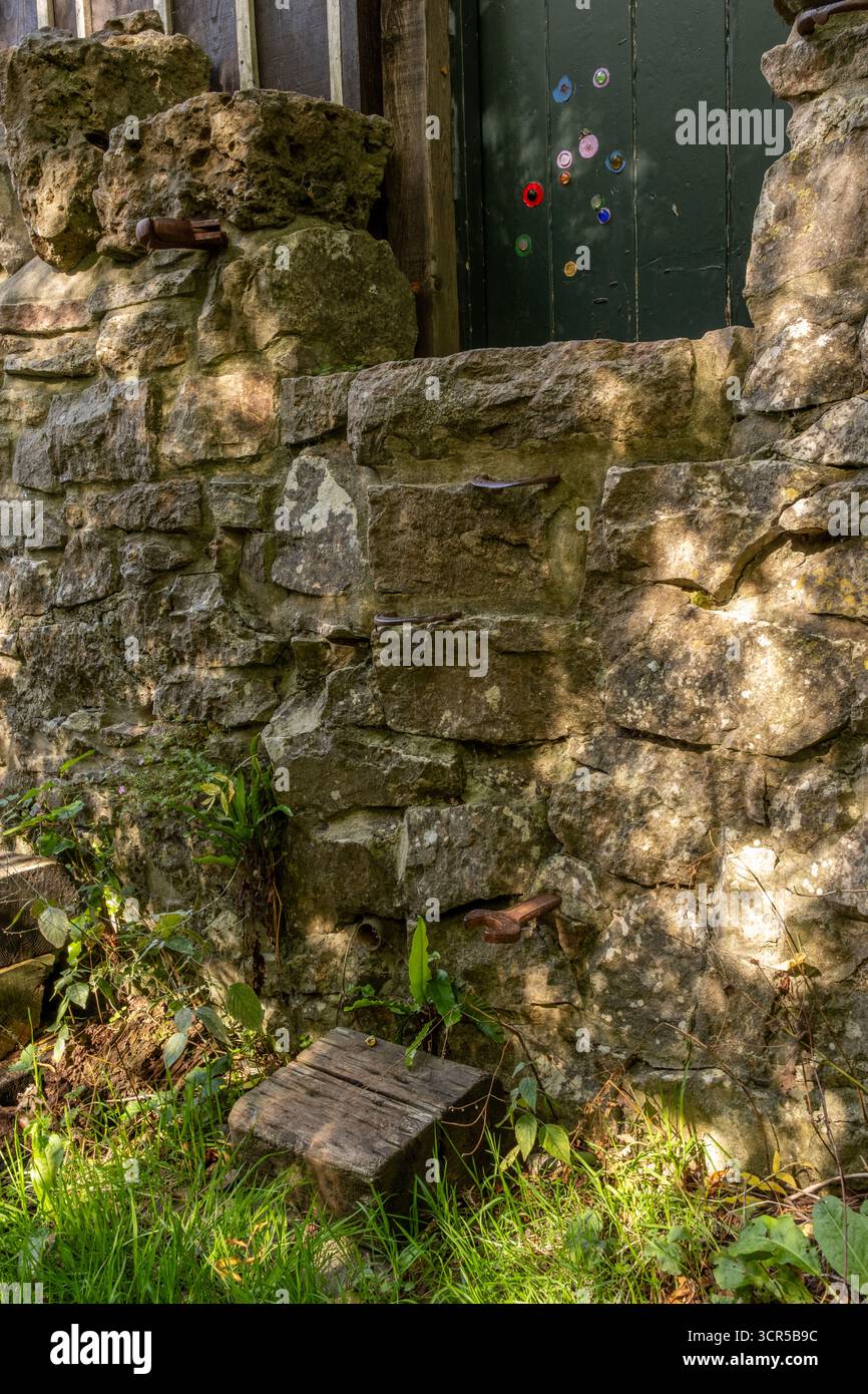 September 2025 - Steps in a stone wall leading up to a wooden door Stock Photo